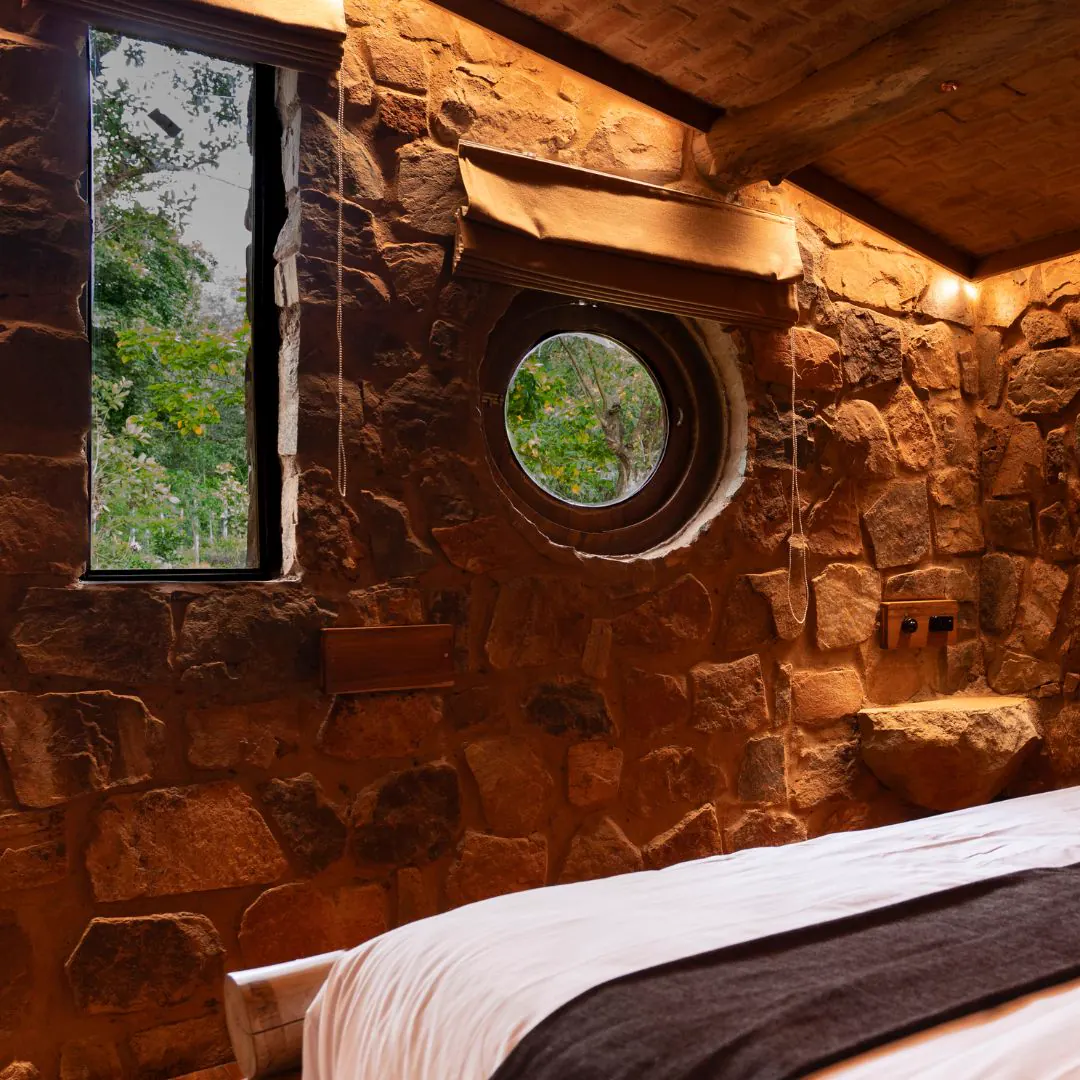 The Burrow — the bedroom, stone walls and porthole windows